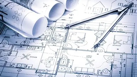 House blueprints with rolled plans and a drafting compass
